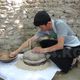 Фото ИА «24.kg». Участник показывает, как пользоваться жерновами, село Жаны-Жер, 23 мая 2017 года 